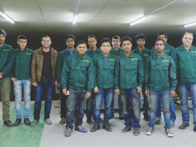Elevator installation team in factory uniforms posing together