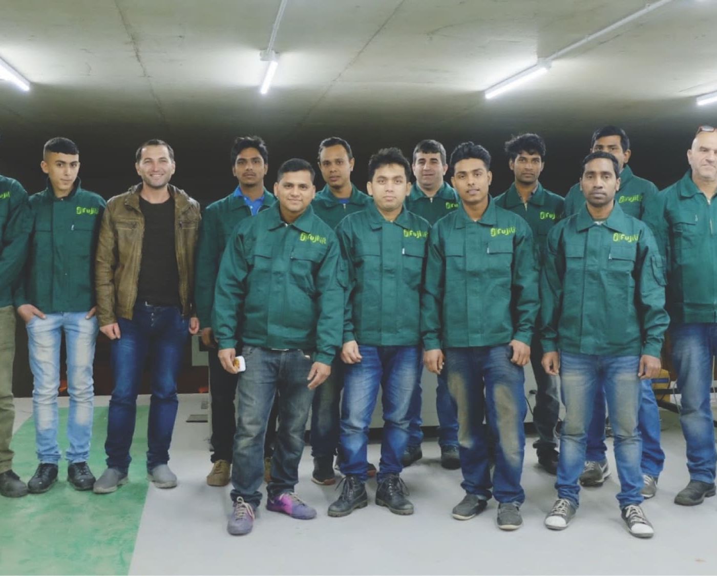 Elevator installation team in factory uniforms posing together