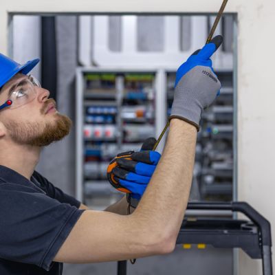 Electrician installing laying electrical cables on elevator