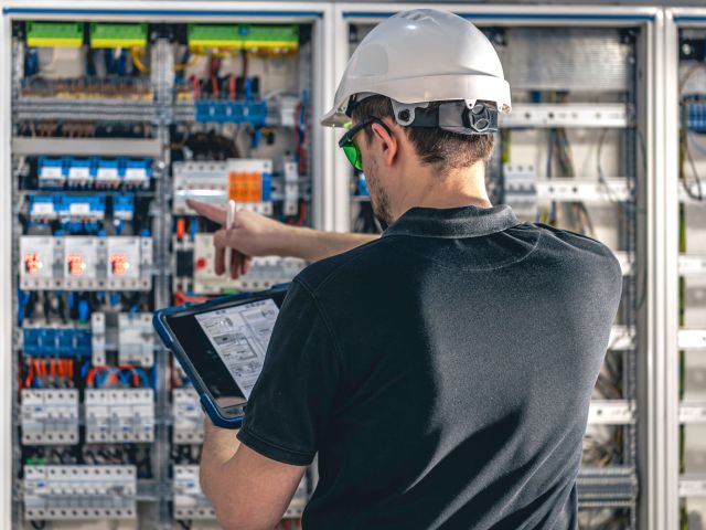 man electrical working switchboard with fuses for elevator