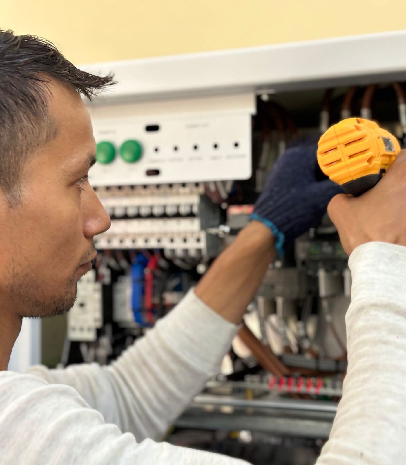 Technician repairing components inside an elevator control cabinet